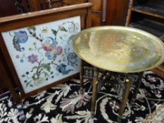 AN EDWARDIAN MAHOGANY FRAMED FIRESCREEN with interior needlework panel and a Benares type brass