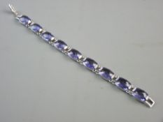 A SWAROVSKI BELIEVED SILVER BRACELET of nine oblong faceted purple stones, 25 grms total with