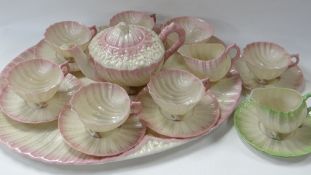 A BELLEEK TEA SERVICE IN THE NEPTUNE PATTERN comprising tray, teapot, six cups and saucers, sugar
