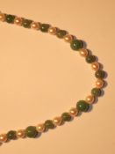 A pearl and jade necklace set in alternate order,