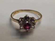 9 carat gold cluster ring with central red stone,