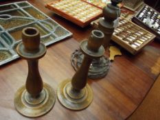 A pair of wooden candle stick and a wooden table l