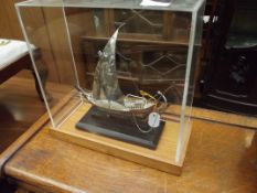 White metal model of a yacht in a case