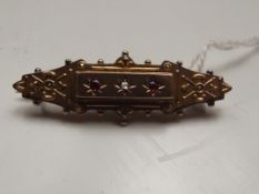 9ct gold brooch with 2 red stones and 1 central di