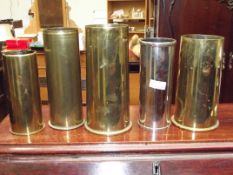 Four brass shell cases together with a plated exam