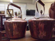 Two copper kettles with acorn finials