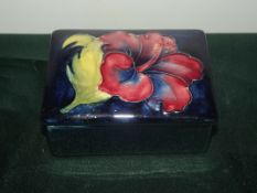 Moorcroft lidded trinket box in the Hibiscus pattern, length 9cm