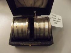 Cased pair of silver engine turned napkin rings, D