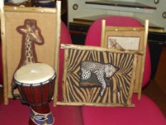 Three African wall canvases together with a drum