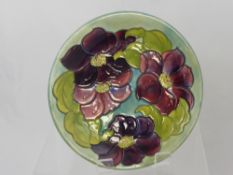 A Moorcroft Plate, 'Clematis' design, with Royal Warrant Label to verso 'Potters to the Late Queen