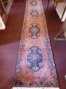 A 20th Century Iranian Wool Runner, navy blue on pink ground with four central gül, approx 415 x