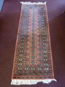 A Contemporary Pink Woollen Runner, with central floral gül, approx 190 x 66 cms.