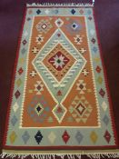 A 20th Century Middle Eastern Woollen Carpet of muted colouring, grey and pink geometric border in