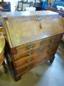 A Georgian Oak Drop Front Bureau, the bureau having four graduated drawers and on bracket feet