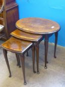 A Walnut and Mahogany Nest of Tables, the oval nest on cabriole legs, approx 57 x 41 x 52 cms.