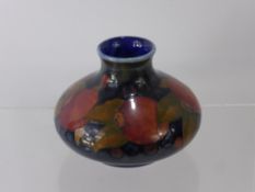 William Moorcroft, 'Pomegranate' Vase, the vase of squat form, on green blue ground, factory marks
