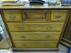 An Edwardian Chest of Drawers, two short and three long drawers, with a central cupboard, with brass