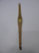 A Lady's 9 ct Gold Zenith Integral Bracelet Watch, the watch having bark finish, gold face and baton