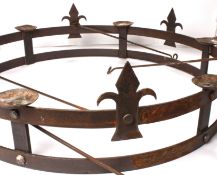A large wrought iron hanging chandelierwith six candle bowls and mounted with fleur de lys on a