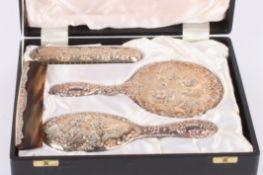 A contemporary embossed silver dressing table sethallmarked Birmingham 1977, decorated with