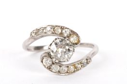 A diamond set scroll twist ring the central diamond measures over 0.5ct within graduated diamond