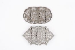 A hallmarked silver nurses two piece buckle of pierced and engraved daffodil design, and another