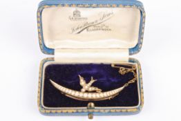 An Edwardian pearl set swallow upon a crescent brooch, marked 9ct to the reverse, with safety