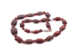 A 1930s gold and garnet necklace with 9ct white gold clasp and strung with graduated rectangular