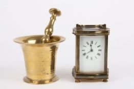 A brass carriage clock timepiece the white enamel dial with black Roman numerals and carrying