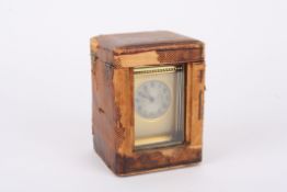 A late Victorian brass carriage clock the circular silvered engine turned dial with black Roman