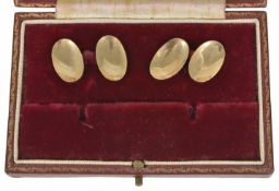 A pair of Art Deco 9ct gold cufflinks of oval convex form and linked with chains