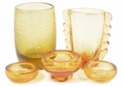 A collection of Whitefriars amber glassware comprising three ashtrays and two vases the largest vase