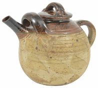 A large pottery teapot with streaked brown glaze to lid and spout, stamped on the