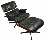 A Charles and Ray Eames rosewood and black leather lounge chair and ottoman (a.f) approximately