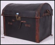 A vintage tan leather and canvas dome top trunk, c1900, brass clasp to front.
