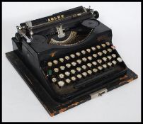 A vintage cased early 20th century reporters typewriter by Adler of Frankfurt.