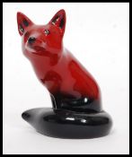 A Royal Doulton Flambe figure of a seated fox, bold black and red colouring,