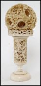 A circa 1900 Chinese carved and pierced ivory puzzle ball on stand.