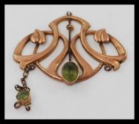 A late Victorian high Art Nouveau 9ct gold and peridot set pendant.
