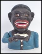 A vintage style cast iron hand painted money box in the form of a ' Jolly Negro ' with moving hand