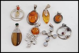 A collection of 925 silver brooches and pendants.