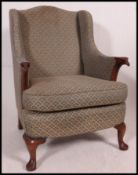 An Edwardian wing back chesterfield armchair with eagles head armrests.