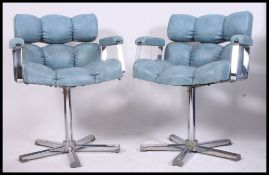 A pair of retro 1970's chrome and blue vinyl upholstered offie swivel chairs.
