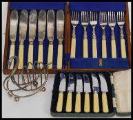 An Edwardian mahogany cased canteen of cutlery together with a cased set of knives and a silver