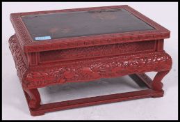 A late 19th / early 20th century Chinese red laquered hardwood low tea / opium table  having a