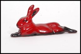 A Royal Doulton Flambe figure of a lying rabbit, bold black and red colouring,