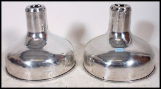 A set of 2 polished steel 20th century Industrial pendant shades.