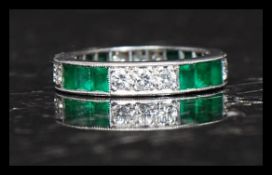 An 18ct platinum, diamond and emerald eternity ring.