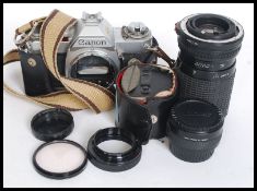 An assorted collection of camera spares and accessories to include a Canon AV1 Body,