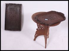 A profusely carved Kashmiri hardwood tray together with another, each of rectangular form.